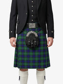 Person wearing a traditional Scottish kilt with a tartan pattern on a white background