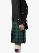 Person wearing a dark jacket and green plaid kilt on a white background