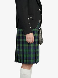 Person wearing a black jacket and green plaid kilt on a white background