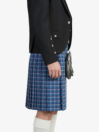 Person wearing a black blazer and blue plaid kilt on a white background
