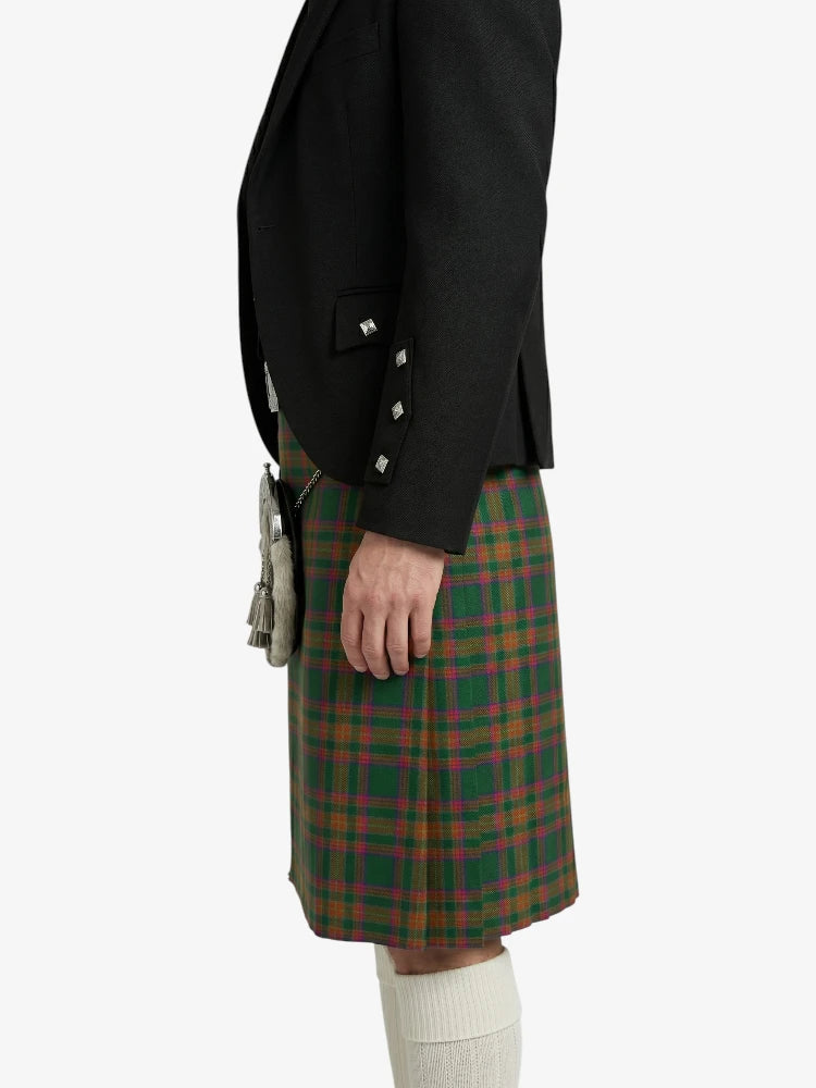 Person wearing a black jacket and green plaid kilt on a white background