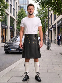 A man stands on a city sidewalk wearing a black leather kilt with gold buttons, a white t-shirt, white knee-high socks, and black leather shoes. The background shows a street with buildings, a parked black Mercedes, and a bicycle.