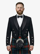 Man wearing a black prince charlie jacket with a black stewart tartan kilt on a white background