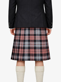 Person wearing a black jacket and plaid kilt on a white background