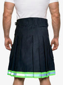Person wearing a black pleated kilt with green trim on a white background
