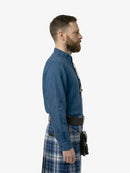 Man wearing a blue shirt and plaid kilt on a white background