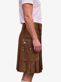 A side view of a person wearing a brown faux-leather kilt with pleated detailing and a large front flap pocket, paired with a white t-shirt against a plain white background.