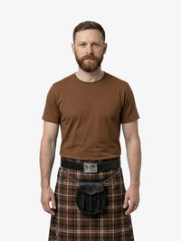 Man wearing a brown t-shirt and plaid kilt on a white background