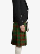 Person wearing a black blazer and green plaid kilt on a white background