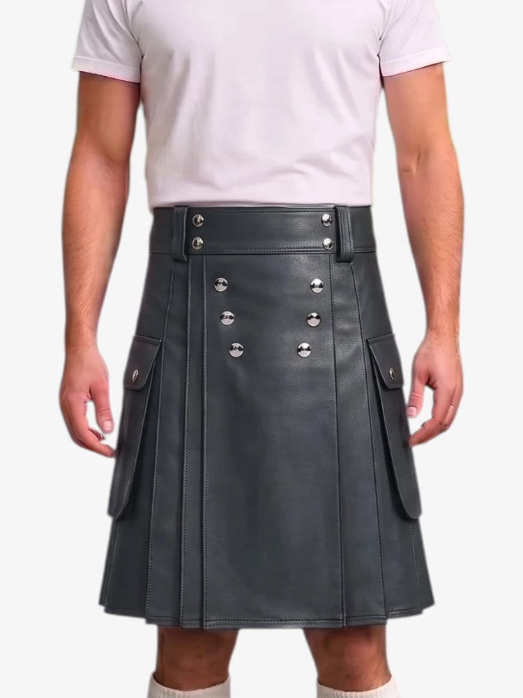 A person wearing a dark gray faux-leather kilt with silver-tone metal rivets and flap pockets, paired with a light pink t-shirt, shown against a plain white background.