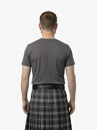 Man wearing a gray t-shirt and plaid kilt on a white background