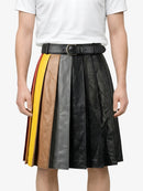 Person wearing a black leather skirt with color-blocked sides on a white background