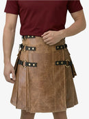 Person wearing a brown leather kilt with black straps and gold buckles on a white background