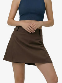 Woman wearing a brown skirt and blue top on a white background