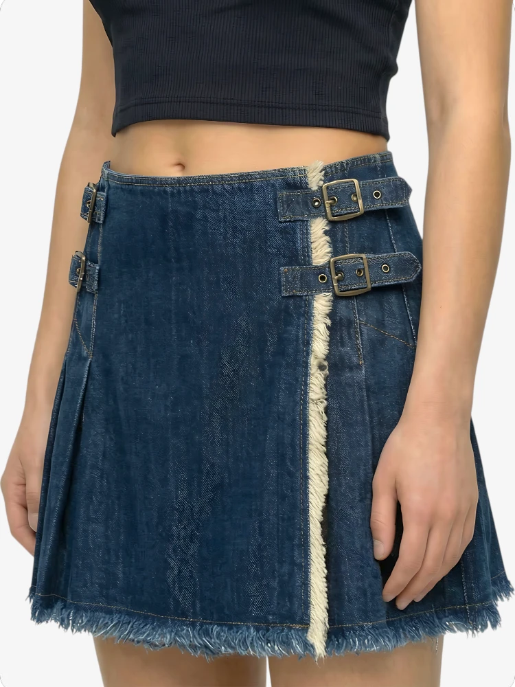 Denim skirt with metal buckles worn by a person on a white background
