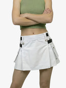 Person wearing a white skirt with black straps on a plain background