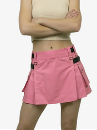 Person wearing a pink skirt with black straps on a white background