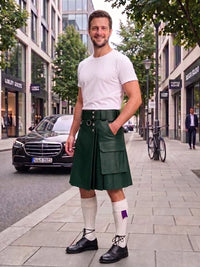 A man stands on a city sidewalk wearing a dark green leather kilt, a white t-shirt, white knee-high socks, and black leather shoes. The background shows a street with buildings, a black Mercedes-Benz car, and a bicycle.