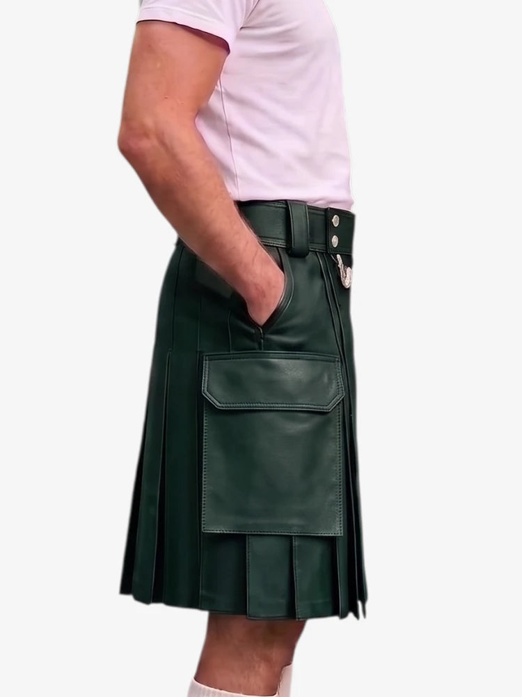 A dark green faux-leather kilt with pleated detailing, a front flap pocket, and a belt with silver-tone buttons, shown on a model wearing a light pink t-shirt against a white background.