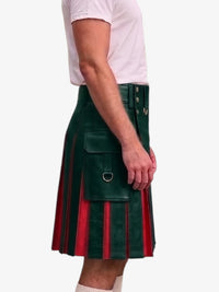 A side view of a person wearing a pleated kilt in navy blue and red, paired with a light pink t-shirt and white socks, against a plain light gray background.