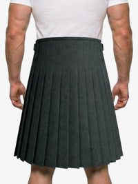 Person wearing a gray pleated kilt on a white background