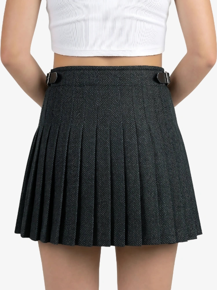 Person wearing a black pleated skirt on a plain background