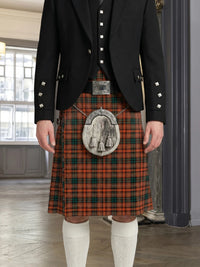 Person wearing a traditional Scottish kilt with a jacket indoors.