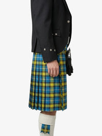 Person wearing a black jacket and blue and yellow plaid kilt on a white background
