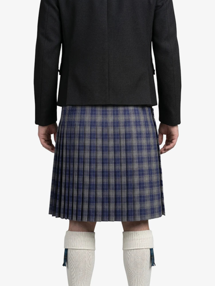Person wearing a black jacket and plaid kilt on a white background