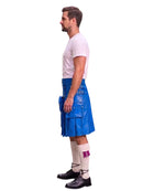 A man shown in profile wearing a bright blue leather kilt, a white t-shirt, white socks, and black shoes, standing against a plain white background.