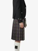 Person wearing a black jacket and plaid kilt on a white background