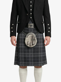Person wearing a black jacket, plaid kilt, and white knee-high socks on a white background