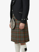 Person wearing a black jacket and red plaid kilt on a white background