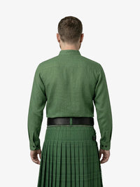 Man wearing a green shirt and kilt on a white background