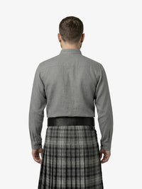Man wearing a gray shirt and plaid kilt on a white background
