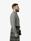 Man wearing a gray shirt and plaid kilt on a white background