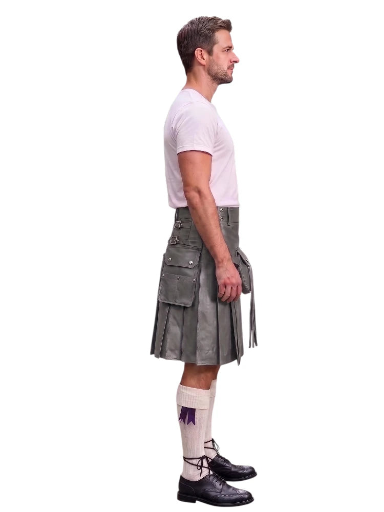 A man shown in profile wearing a gray kilt, white t-shirt, white knee-high socks, and black leather shoes against a plain white background.