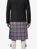 Person wearing a black coat and plaid kilt on a white background