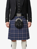 Person wearing a traditional Scottish kilt with a sporran on a white background