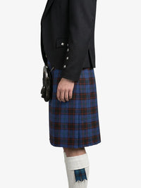 Person wearing a black jacket and blue plaid kilt on a white background