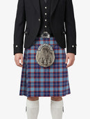 Person wearing a traditional Scottish kilt with a tartan pattern on a white background