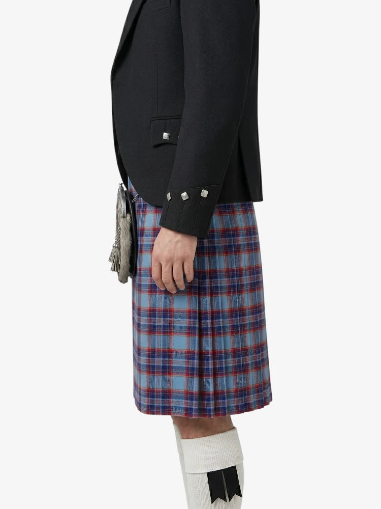 Person wearing a black jacket and blue plaid kilt on a white background