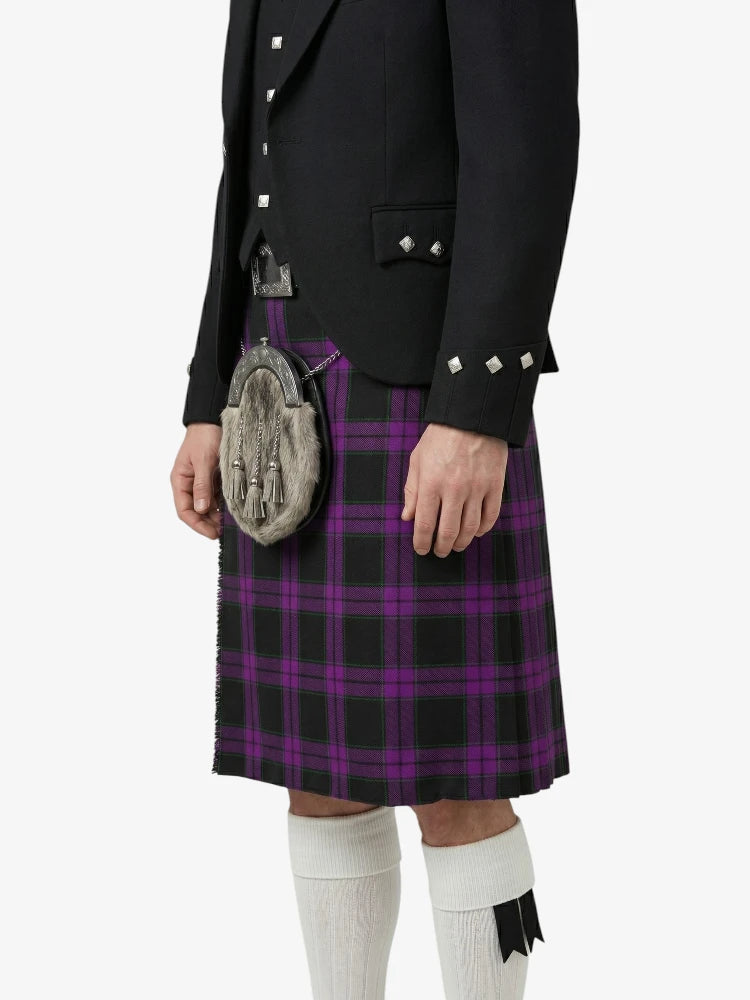 Person wearing a black jacket and purple plaid kilt on a white background