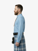 Man wearing a blue shirt and plaid kilt on a white background