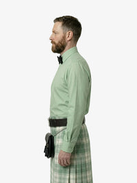Man wearing a green shirt and plaid kilt on a white background