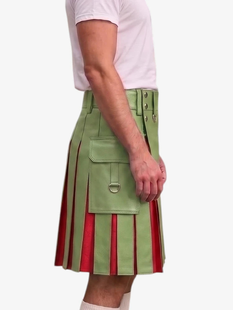 A side view of a person wearing a green leather kilt with red pleated inserts, paired with a light pink t-shirt, against a plain white background.