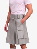 A person wearing a light gray pleated kilt-style skirt with a wide belt, metal hardware, and large cargo pockets, paired with a pale pink T-shirt against a plain light background.