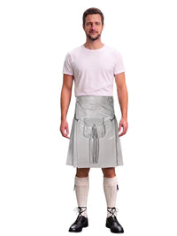 A man modeling a gray faux-leather kilt costume with a matching waist bag and tassel, worn over a light pink t-shirt, cream knee-high socks, and black lace-up shoes, on a white background.