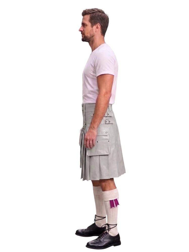 A man shown in profile wearing a light gray pleated kilt, a white t-shirt, white socks with a purple accent, and black shoes, against a plain white background.