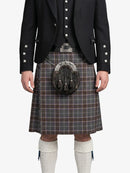 Person wearing a traditional Scottish kilt with a jacket on a white background